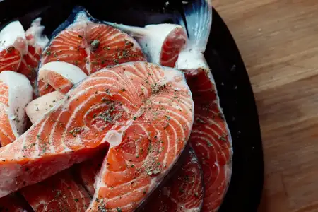 Маринованная красная рыба на тарелке, приготовление морепродуктов, деликатес