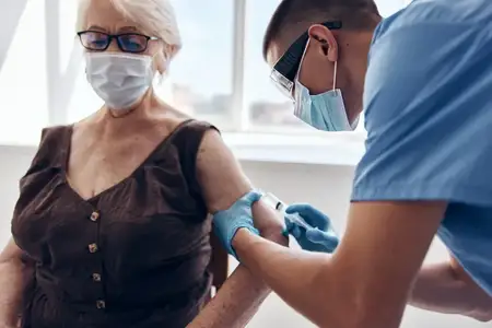 Врач-мужчина делает инъекцию, что символизирует безопасность вакцинации и заботу о здоровье
