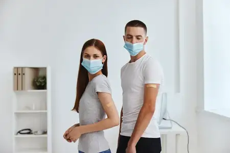 Мужчина и женщина в медицинских масках, паспорт вакцинации от COVID-19