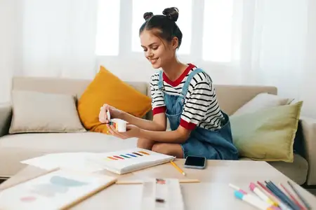 Счастливый подросток-художник создаёт милый портрет дома: расцветающее хобби на диване