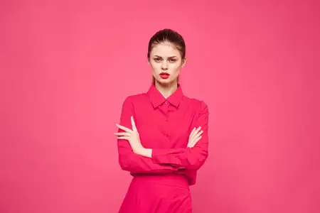 Женщина на розовом фоне в модной одежде и с ярким макияжем, прическа, модель, свободное пространство