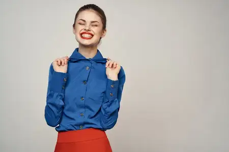 Женщина-модель в синей рубашке и красной юбке, очки, красивое лицо, макияж, студия