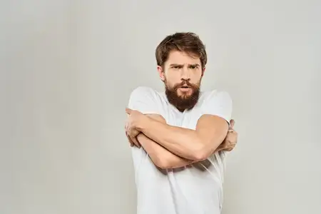 Мужчина в белой футболке жестикулирует руками, выражая недовольство
