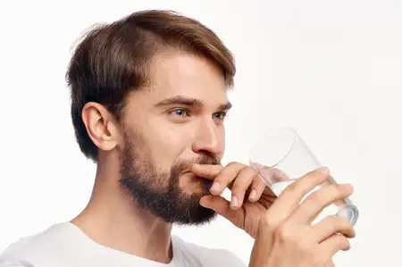 Красивый мужчина на светлом фоне, заботящийся о своем здоровье