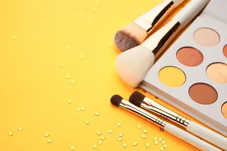 Кисти для макияжа, декоративная косметика для женщин, аксессуары на желтом фоне