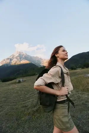 Активная женщина совершает поход в горы с рюкзаком, наслаждаясь свежим воздухом и приключениями на природе