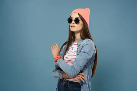 Крупный план женщины в солнцезащитных очках и розовой шляпе, одетой в модную одежду