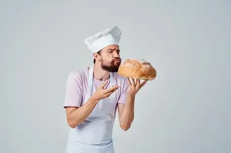 Эмоциональный повар с хлебом в руках, выпечка, кулинария