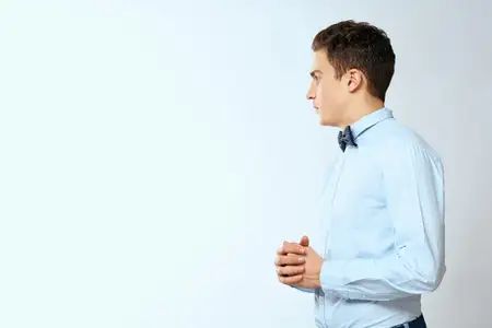 Мужчина в синей рубашке и бабочке, уверенность в себе, светлый студийный фон