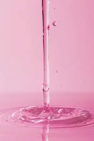 Розовая жидкость вливается в воду с каплей розовой жидкости