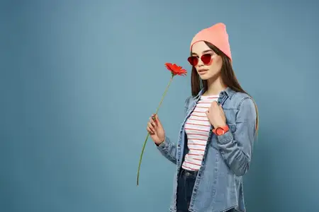 Красивая женщина в розовой шляпе и солнцезащитных очках с красным цветком, романтика
