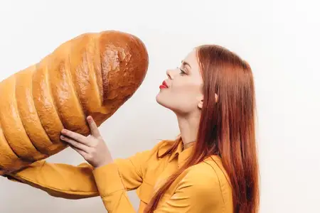 Красивая женщина с буханкой хлеба на цветном фоне, веселые эмоции, модель