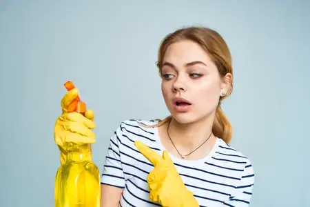 Уборщица в резиновых перчатках, домохозяйка с моющим средством