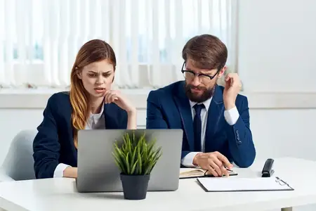 Руководители общаются в офисе перед ноутбуком