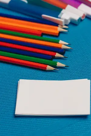 Цветные карандаши, визитные карточки, синий фон, свободное пространство