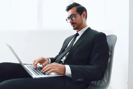 Мужчина сидит в офисном кресле и празднует успех