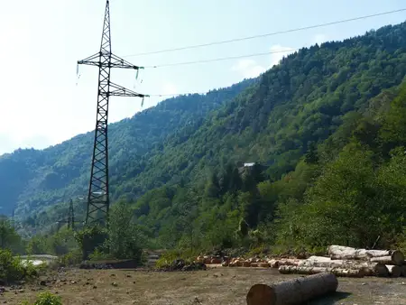 Горный лес и линия электропередачи, пересекающая зеленый склон холма