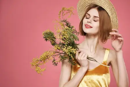 Красивая женщина в шляпе и золотом платье с букетами цветов, праздник
