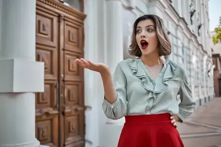 Весёлая женщина в красной юбке гуляет по городу, наслаждаясь досугом летом