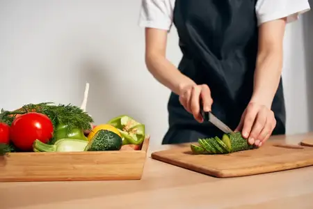 Приготовление свежего овощного салата на кухне