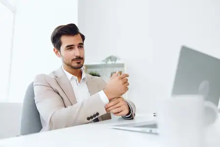 Профессиональный мужчина испытывает радость, работая за ноутбуком в интернете в офисе