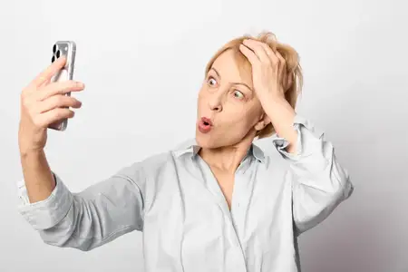 Удивлённая женщина в позе для селфи со смартфоном