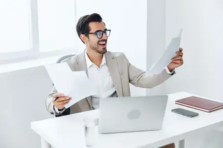Бизнесмен в деловом костюме, работающий за ноутбуком в офисе