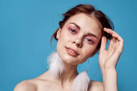 Женщина с обнаженными плечами, ярким макияжем, декор, мода, синий фон