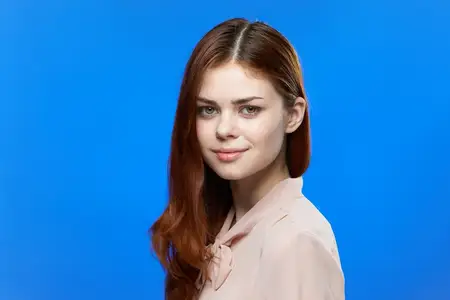 Привлекательная женщина в розовой рубашке с длинными волосами, модель, на голубом фоне