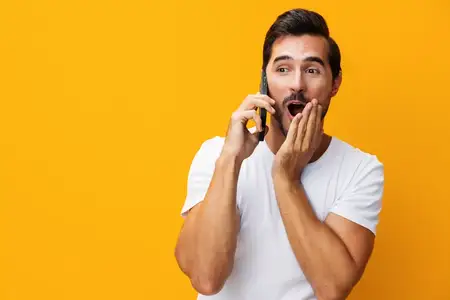 Улыбающийся мужчина в студии с мобильным телефоном