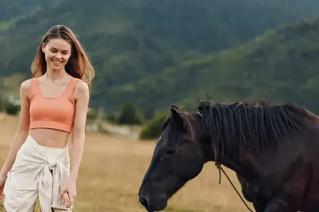 Веселая женщина и лошадь разделяют безмятежный момент на открытом пастбище