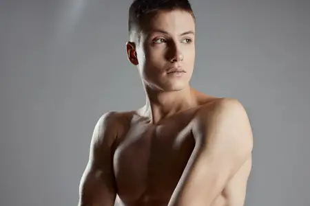 Спортсмены с накачанными мышцами, руки от кубиков пресса на сером фоне, крупным планом