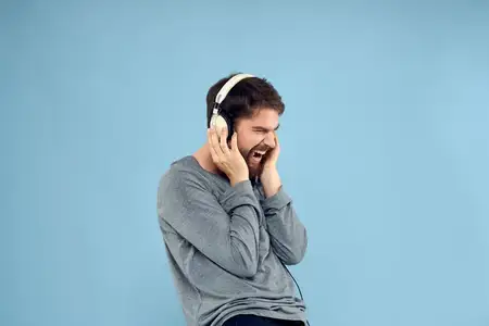 Мужчина в наушниках, музыка, эмоции, образ жизни, современный стиль, технологии, синий фон