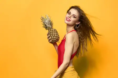 Симпатичная женщина с ананасом в руках, косметика, экзотические фрукты, жёлтый фон, веселье