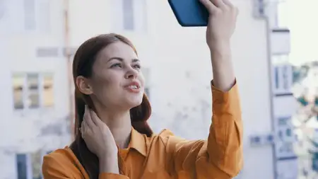Симпатичная женщина с телефоном в руках на открытом воздухе, фотография, технологии