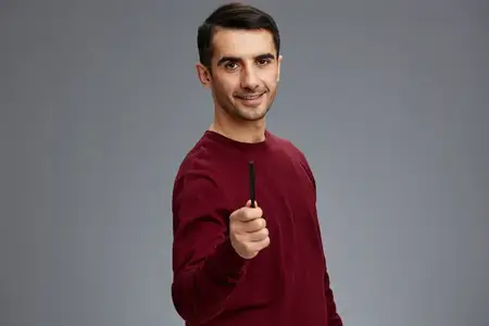 Менеджер позирует с ручкой, жестикулирует руками, красный свитер, изолированный фон