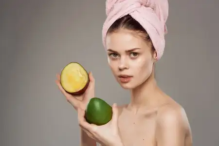 Привлекательная женщина с обнаженными плечами, чистая кожа, в руке манго, обрезанный вид