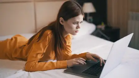 Женщина лежит в кровати перед ноутбуком, фриланс, работа, интернет