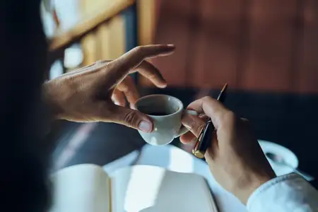 Бизнесвумен в кафе с книгой на столе, документами и чашкой кофе — рабочий образ жизни