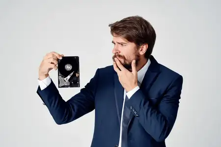 Эмоциональный мужчина занимается восстановлением информации с жёсткого диска с использованием технологий