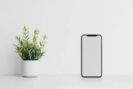 Стильный макет смартфона, размещенный рядом с декоративным зеленым растением в минималистичной обстановке, идеально подходит для технологических и жизненных тем, демонстрируя современную…