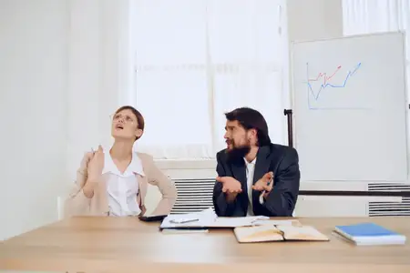 Эмоциональные мужчина и женщина общаются на работе с коллегами