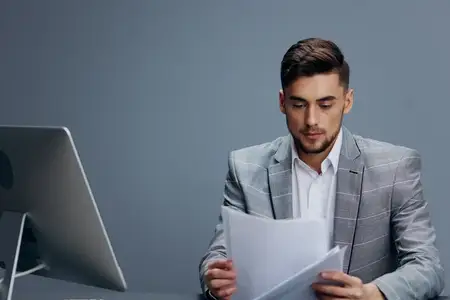 Менеджер работает за компьютером в офисе на сером фоне