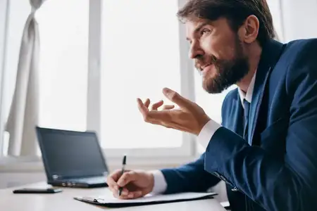 Бизнесмены работают за ноутбуком в офисе, испытывая эмоции и используя технологии