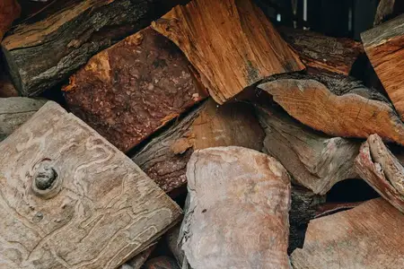 Дрова, сложенные дрова, поленница, колотые дрова, деревенский крупный план текстуры на открытом воздухе, естественные узоры коры и следы распила на расколотых бревнах, подготовка к зиме, топливо для…