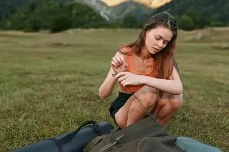Энтузиаст outdoor готовит снаряжение на открытом лугу, наслаждаясь спокойствием природы