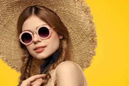 Романтичная женщина в шляпе веселится на желтом фоне