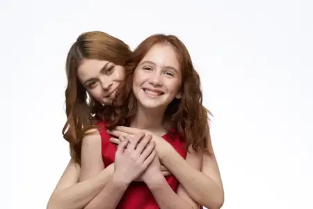 Мама и дочка стоят рядом и веселятся, семейная радость, светлый фон