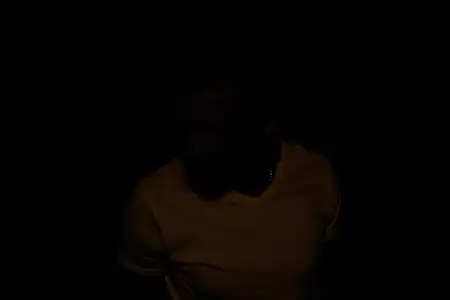 Эмоциональный мужчина в белой футболке с недовольным выражением лица на красном изолированном фоне, кадрированный вид