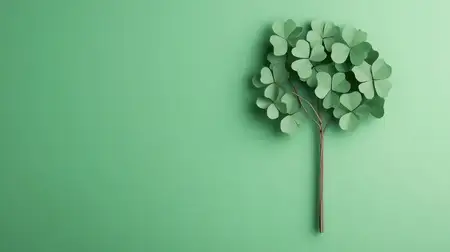 Дерево, вырезанное из зеленой бумаги, с листьями в форме сердечек на мягком зеленом фоне, олицетворяющее природу, любовь и экологичность